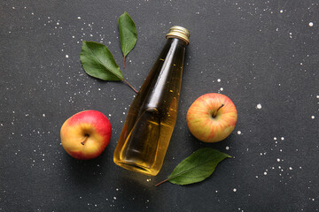 Wall Mural - Composition with fruits, green leaves and bottle of fresh apple cider on black background