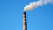 © godfather - Brick chimney with white smoke rising against a clear blue sky.