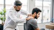 © N7 - Indian Chiropractor with Patient - Indian male chiropractor performing an adjustment or consultation with a patient, showing care in spinal health.