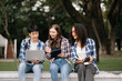 © Nuttapong punna - Young people are spending time together. Reading book, working with laptop and tablet sitting on stairs  Students are studying the campus park.