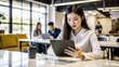 © nilawan - Young businesswoman using digital tablet in office.