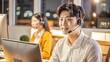 © nilawan - Young Man Working at Computer with Headset.