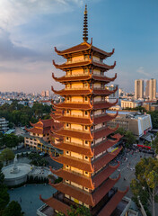 Buddhist Temple with prayer tower in urban setting with beautiful golden afternoon light. City skyline and rooftops can be seen in the background