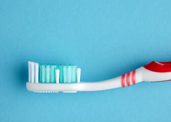 Macro close up view of a plastic toothbrush on blue background. Dental care and hygiene concept.