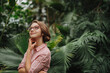© Halfpoint - Small greenhouse business. Businesswoman selling flowers and seedlings, standing in greenhouse, looking at camera, smiling.