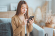 © oatawa - Worried young asian woman looking at smartphone screen, dissatisfied with bad news message, spam or scam sms. Bad mood lifestyle concept.