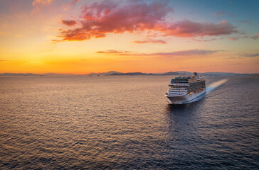Wall Mural - aerial view of a generic cruise ship traveling over the ocean during golden summer sunset time with 
