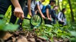 © YUTTADANAI - Group of Young Explorers Using Magnifying Glass to Examine Plants in a Lush Forest