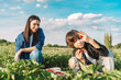 © Westend61 - Mother looking at son gesturing in strawberry field