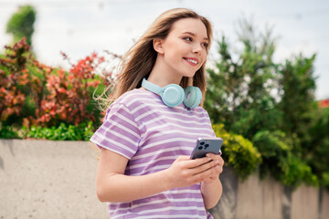 Poster - Photo of positive good mood girl dressed purple t-shirt headphones texting sms modern gadget walking street outdoors uban city town