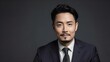 © Royal studio - businessman with a trimmed beard wearing a formal suit  isolated on a gray background, looking serious and professional, suitable for corporate or business projects