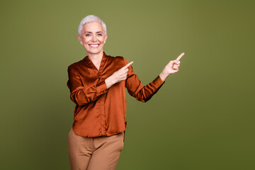 Sticker - Photo portrait of lovely pensioner lady point empty space dressed stylish brown formalwear isolated on khaki color background