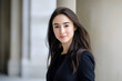 © PixelGallery - Emerging Female Leader Ready for the Corporate World. A young woman with light skin and long dark hair poses in a formal setting, exuding confidence and readiness for a leadership role.