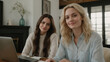 © KraPhoto - Two Young Women Smiling While Working Together in a Cozy Home Office Environment