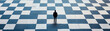 © PTC_KICKCAT - A solitary figure stands on a large checkerboard pattern, symbolizing choice, strategy, and introspection in a vast landscape.