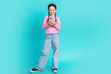 Poster - Photo of cute adorable cheerful girl daughter wear trendy pink clothes hold gadget isolated on cyan color background