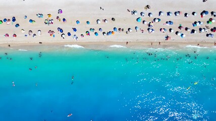 Wall Mural - aerial overhead view of people enjoying the turquoise sea at egremni beach, lefkada island, greece