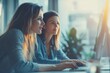 © Picture Perfect - Two business women working together with computer while talking about work in the office, Generative AI