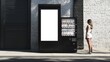 © fotofabrika - A woman stands in front of a modern vending machine on a city street during daylight near a textured brick wall