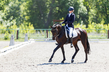 Young equestrian girl performing her dressage test in equestrian competition