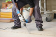 © Antonioguillem - Construction worker using rotary hammer on the floor