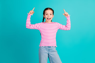 Poster - Photo of charming adorable girl wear stylish striped pink clothes demonstrate offer empty space isolated on cyan color background