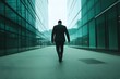 © Pukan - A man in a dark suit walks alone between glass office buildings, evoking a sense of solitude and introspection in a modern urban setting.