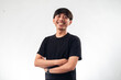 © Daniel - A smiling Asian man in a black t-shirt stands confidently with arms crossed against a plain white background, ideal for professional headshots, personal branding, or business profile content