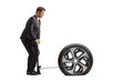 © Ljupco Smokovski - Full length profile shot of a businessman pumping a flat car tire