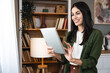 © Srdjan - Real estate agent with tablet pc looking through window. Young business woman working at home, using device gadget. Successful professional occupation graphic designer female taking a break from work.