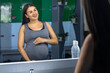 © puhimec - A pregnant woman near a mirror in the gym. A healthy sports lifestyle.