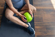 © puhimec - A pregnant woman in the gym sits on a mat with a ball in her hands.