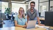 © kinara art design - A smiling man and woman working on a laptop computer in an office setting.