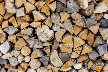 Background of stacked chopped wood logs. Pile of wood logs ready for winter. Wooden stumps, firewood stacked in heap