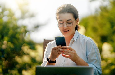 Wall Mural - woman working on laptop in summer morning