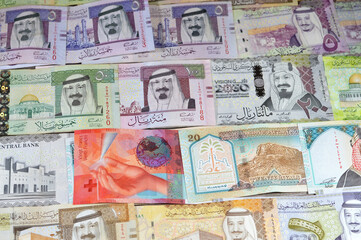 Switzerland cash money of Swiss Francs and Saudi Arabia money banknotes of riyals bills, of different values features various kings of Saudi Arabia, Saudi Arabian and Swiss exchange rate and value