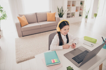 Canvas Print - Photo portrait of small cute daughter sit table laptop earphones online lesson remote education home schooling isolated indoors background