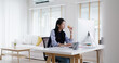 © ChayTee - Asia people young woman MBA student gen Z girl work online on desk at home office multi tasking workforce hurry eat junk meal break time bite vegan meat burger diet. Stress relief by take out food.