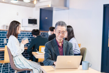 Wall Mural - カフェで仕事をする中年男性