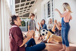 © Marko Geber - Multigenerational family playing soccer on house porch