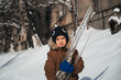 © alexkoral - A Caucasian boy holds an icicle in his hands outside in winter.