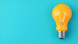 © Bi - Bright Yellow Lightbulb on a Blue Background - Perfect for Inspiration and Innovation Concepts
