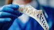© Sasa Visual - A healthcare worker holds a 3D-printed bone model to study its structure and potential applications in patient treatment