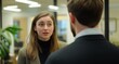 © ME_Photography - A woman speaks to a man in a professional environment, showcasing an engaging discussion amidst office decor.