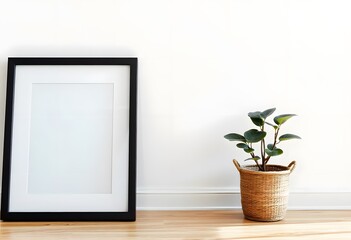 Wall Mural - A black picture frame on a white wall with a potted plant in the foreground