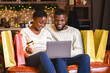 © Prostock-studio - Seasonal sales. Happy african american couple buying Christmas presents online, using laptop and credit card.