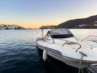 Sticker - Andros island, Cyclades Greece. Inflatable boat moored and waterfront buildings at Gavrio port