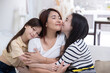 © charnsitr - View of asian mother hug her daughters on couch