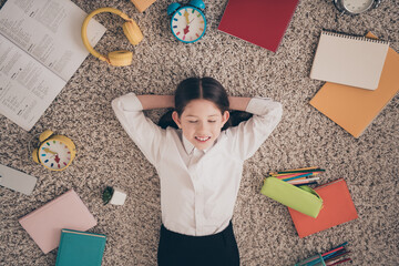 Wall Mural - Photo portrait of small cute daughter lying floor hands behind head done remote education home schooling isolated indoors background