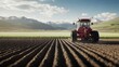 © Sasa Visual - A red tractor operates autonomously, planting seeds across a large, well-tilled field surrounded by mountains